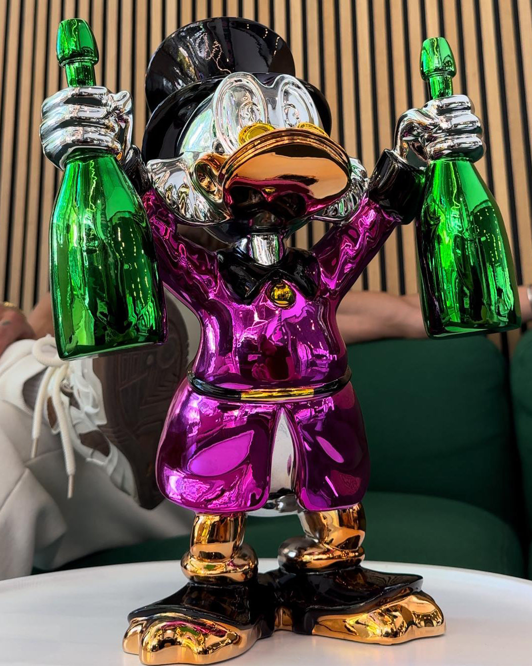 Billionaire Duck Dekoratif Ördek Biblo – Mor, parlak krom kaplama, gümüş ve altın detaylı, iki yeşil şişe tutan.