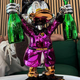 Billionaire Duck Dekoratif Ördek Biblo – Mor, parlak krom kaplama, gümüş ve altın detaylı, iki yeşil şişe tutan.