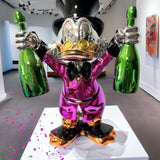 Pop Art Heykel Billionaire Duck biblo, parlak mor emaye kaplama ve iki yeşil şişe tutan detay.