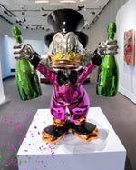 Pop Art Heykel Billionaire Duck biblo, parlak mor emaye kaplama ve iki yeşil şişe tutan detay.