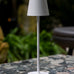 Vermes 38 cm Feline kablosuz şarjlı LED masa lambası, beyaz renkli modern tasarımıyla desenli masa üzerinde.