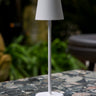 Vermes 38 cm Feline kablosuz şarjlı LED masa lambası, beyaz renkli modern tasarımıyla desenli masa üzerinde.