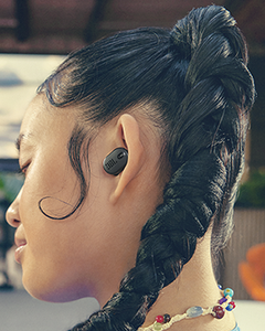 JBL Tune Buds 2 Kablosuz Kulaklık Siyah, saç örgülü bir kadının kulağında takılı yan profilden.