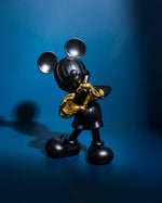 Pop Art Heykel Mickey Mouse Love Dekoratif Biblo, antrasit gövde, altın kalp elleri, mavi fonda.