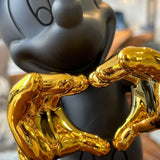 Mickey Mouse Love Dekoratif Biblo – Antrasit 30 cm, parlak altın rengi elleriyle kalp oluşturuyor.
