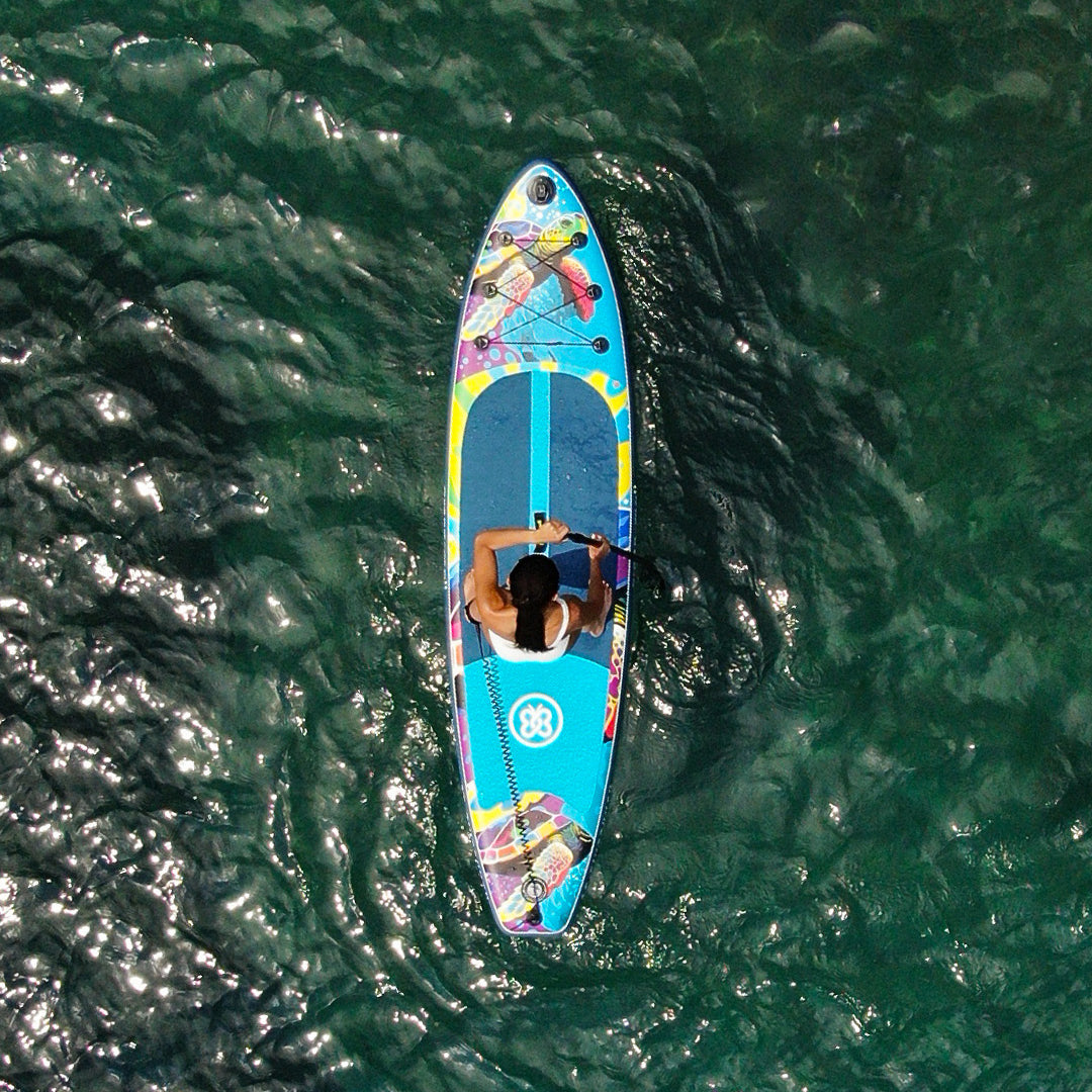 Greenmall 320 cm Turtle şişme SUP paddle board üzerinde berrak suda kürek çeken kadın, kuş bakışı görünüm.